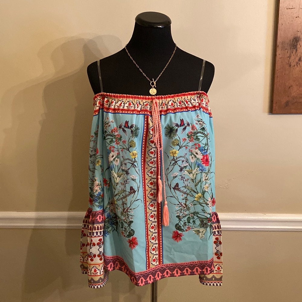 Floral off-the-shoulder Umgee blouse w/ tassels on front.